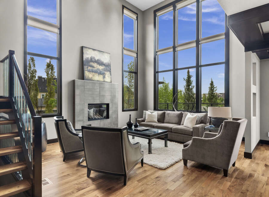 Experience luxury living in this stunning modern living room, featuring soaring floor-to-ceiling windows that flood the space with natural light and offer breathtaking views.