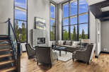 Experience luxury living in this stunning modern living room, featuring soaring floor-to-ceiling windows that flood the space with natural light and offer breathtaking views.
