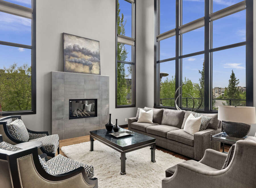 Experience luxury living in this stunning modern living room, featuring soaring floor-to-ceiling windows that flood the space with natural light and offer breathtaking views.