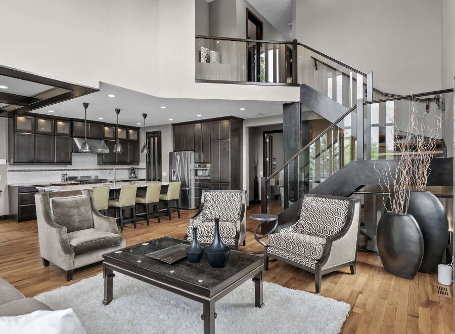 Experience luxury living in this stunning open-concept home, featuring a gourmet kitchen with dark wood cabinetry and a spacious island perfect for entertaining.