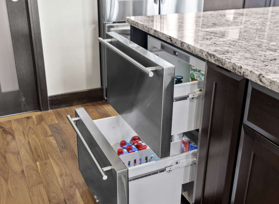 Experience modern convenience with this sleek kitchen featuring integrated stainless steel drawers, perfect for a built-in refrigerator or freezer.