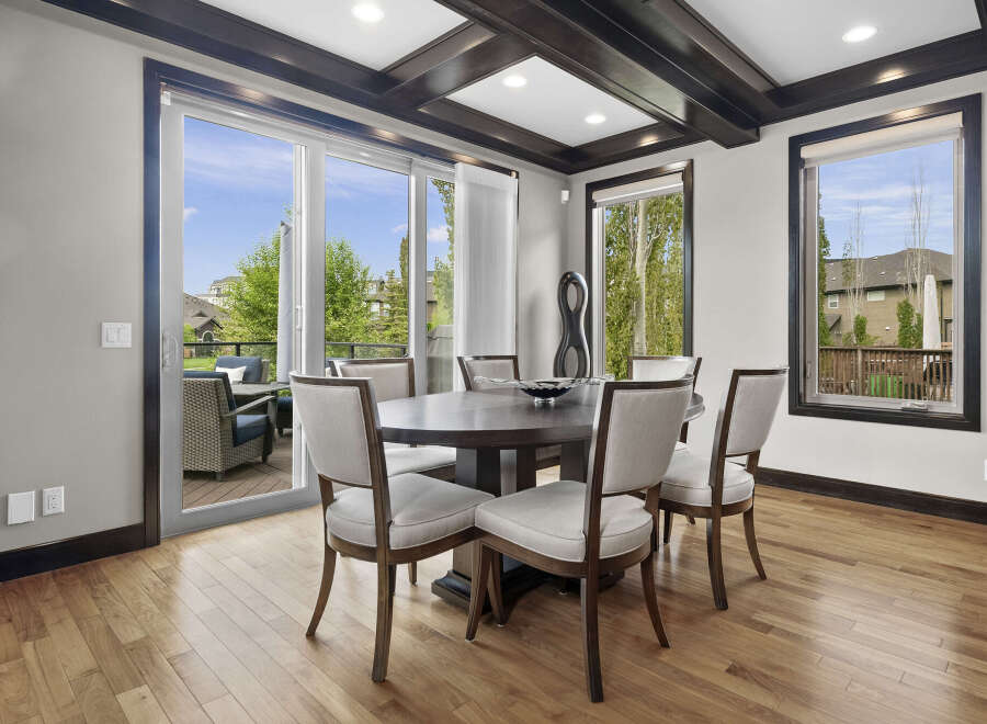 This elegant dining room features a round dark wood table surrounded by six upholstered chairs, perfect for intimate gatherings.