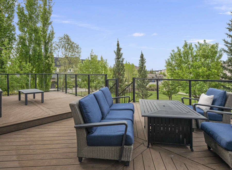 Enjoy outdoor living on this spacious deck, featuring comfortable seating and a fire pit table perfect for gatherings.