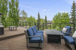 Enjoy outdoor living on this spacious deck, featuring comfortable seating and a fire pit table perfect for gatherings.