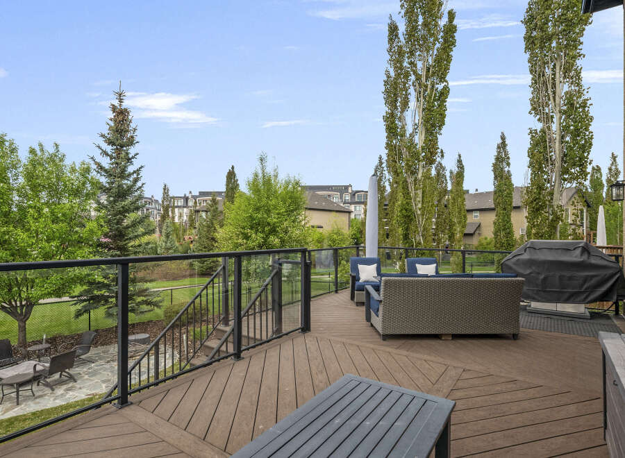 Enjoy outdoor living on this expansive deck featuring comfortable seating and a covered grill, perfect for entertaining.