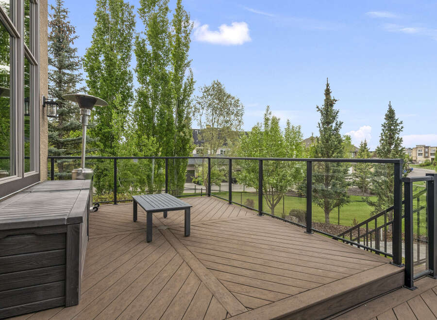 Enjoy outdoor living on this spacious deck featuring a modern glass railing and comfortable seating area.