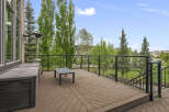 Enjoy outdoor living on this spacious deck featuring a modern glass railing and comfortable seating area.