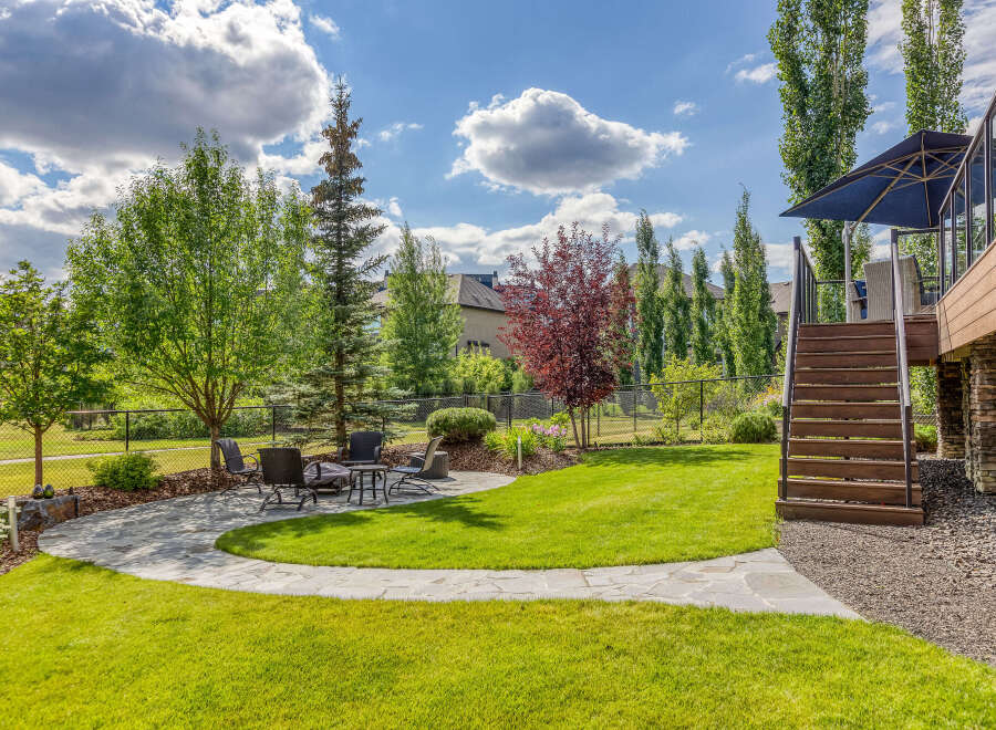 Enjoy outdoor living in this beautifully landscaped backyard featuring a flagstone patio with a fire pit and seating area.