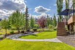 Enjoy outdoor living in this beautifully landscaped backyard featuring a flagstone patio with a fire pit and seating area.