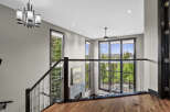 Experience modern luxury in this stunning home featuring a grand staircase with glass railings and a sleek chandelier.