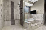 Experience ultimate relaxation in this luxurious master bathroom, featuring a spacious walk-in shower with multiple shower heads and a built-in bench.