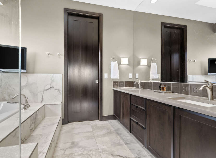 Indulge in luxury with this stunning bathroom featuring a deep soaking tub and a spacious double vanity.