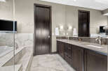 Indulge in luxury with this stunning bathroom featuring a deep soaking tub and a spacious double vanity.