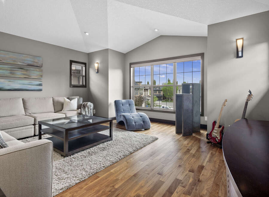 Experience modern living in this spacious living room, featuring a comfortable sectional sofa, a sleek coffee table, and a unique blue chaise lounge.