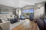 Experience modern living in this spacious living room, featuring a comfortable sectional sofa, a sleek coffee table, and a unique blue chaise lounge.