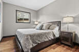 Experience comfort and style in this beautifully appointed bedroom, featuring a plush queen-size bed adorned with elegant bedding and decorative pillows.