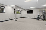 Transform this versatile basement space into your personal home gym, complete with a mounted flat-screen TV for entertainment and a multi-functional weight machine.