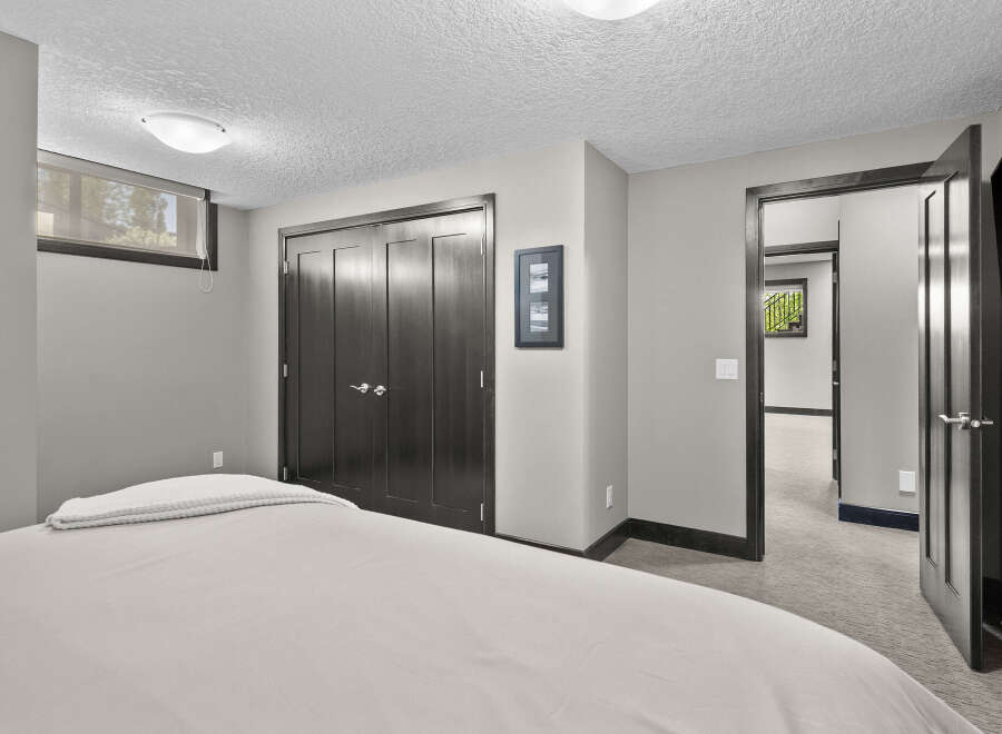 Discover comfort and style in this inviting bedroom, featuring a plush bed with a neatly folded throw blanket.