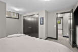 Discover comfort and style in this inviting bedroom, featuring a plush bed with a neatly folded throw blanket.