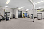 Transform this spacious basement into your ultimate home gym, complete with a versatile weight bench, a full rack of dumbbells, and multiple cardio machines like a treadmill and stationary bikes.