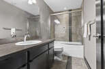 This modern bathroom features a sleek vanity with a white undermount sink and a chrome faucet, complemented by a large mirror.