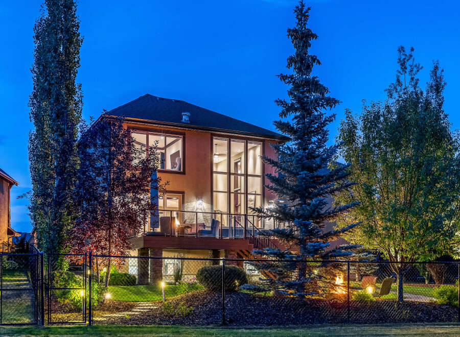 Experience luxury living in this stunning home featuring a multi-level deck perfect for entertaining and enjoying the twilight ambiance.