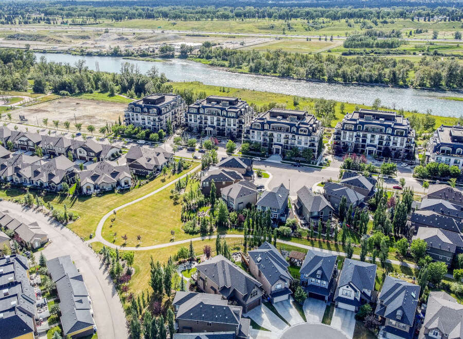 Discover modern living in this stunning aerial view of a vibrant community featuring elegant apartment buildings and charming single-family homes.