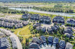 Discover modern living in this stunning aerial view of a vibrant community featuring elegant apartment buildings and charming single-family homes.
