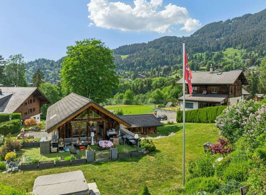 Experience serene mountain living in this charming property featuring a spacious wooden chalet with a large glass facade, perfect for enjoying the picturesque views.