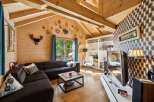 Experience cozy living in this charming wooden cabin-style living room, featuring a spacious sectional sofa perfect for relaxation.