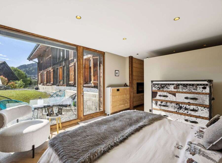 Experience rustic luxury in this stunning bedroom featuring a cozy fireplace and unique cowhide dresser.