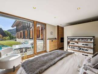 Experience rustic luxury in this stunning bedroom featuring a cozy fireplace and unique cowhide dresser.