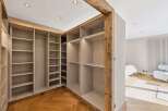 Discover this spacious walk-in closet featuring ample shelving and hanging space, perfect for organizing your wardrobe.
