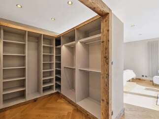 Discover this spacious walk-in closet featuring ample shelving and hanging space, perfect for organizing your wardrobe.
