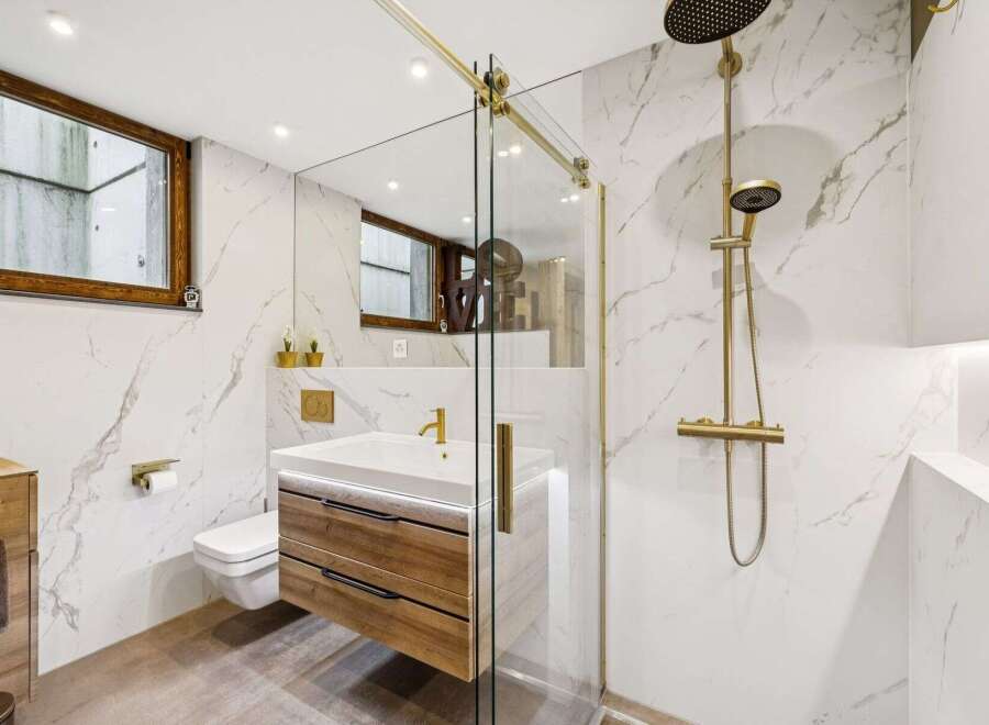Experience modern luxury in this stunning bathroom featuring a sleek vanity with wooden drawers and a floating design.