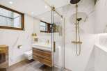 Experience modern luxury in this stunning bathroom featuring a sleek vanity with wooden drawers and a floating design.
