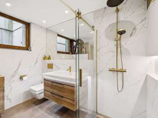 Experience modern luxury in this stunning bathroom featuring a sleek vanity with wooden drawers and a floating design.