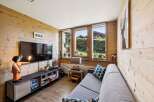 Experience cozy living in this charming room featuring warm wood paneling throughout.