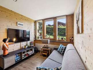 Experience cozy living in this charming room featuring warm wood paneling throughout.