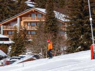Experience the ultimate alpine lifestyle in this stunning wooden chalet, nestled amidst snow-covered pine trees.