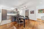 Experience modern living in this open-concept kitchen and dining area, featuring sleek cabinetry and a spacious island perfect for entertaining.