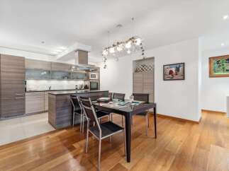 Experience modern living in this open-concept kitchen and dining area, featuring sleek cabinetry and a spacious island perfect for entertaining.