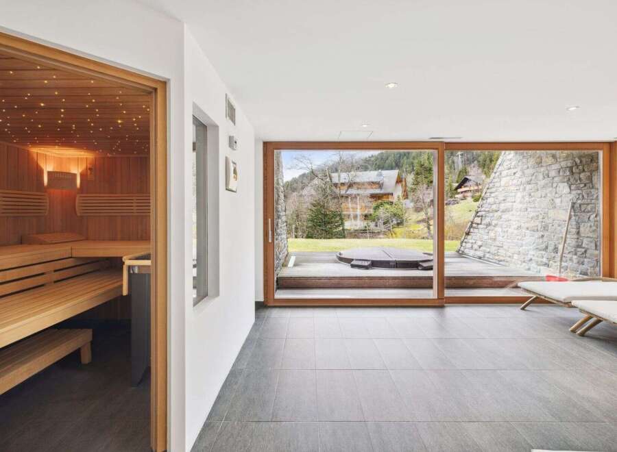 Experience ultimate relaxation in this luxurious spa area, featuring a beautifully crafted wooden sauna with ambient lighting.
