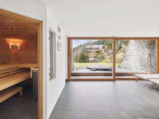 Experience ultimate relaxation in this luxurious spa area, featuring a beautifully crafted wooden sauna with ambient lighting.