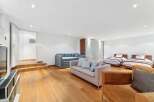 This spacious room offers a versatile living and sleeping area, featuring two comfortable sofas and two twin beds perfect for guests.