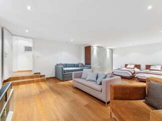 This spacious room offers a versatile living and sleeping area, featuring two comfortable sofas and two twin beds perfect for guests.