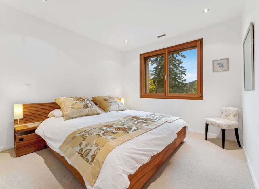 This inviting bedroom features a comfortable queen-size bed adorned with decorative pillows and a stylish throw.