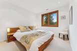 This inviting bedroom features a comfortable queen-size bed adorned with decorative pillows and a stylish throw.