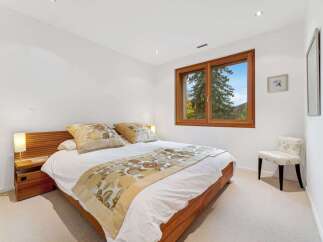 This inviting bedroom features a comfortable queen-size bed adorned with decorative pillows and a stylish throw.