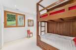 This charming bedroom features a sturdy wooden bunk bed, perfect for accommodating guests or family.